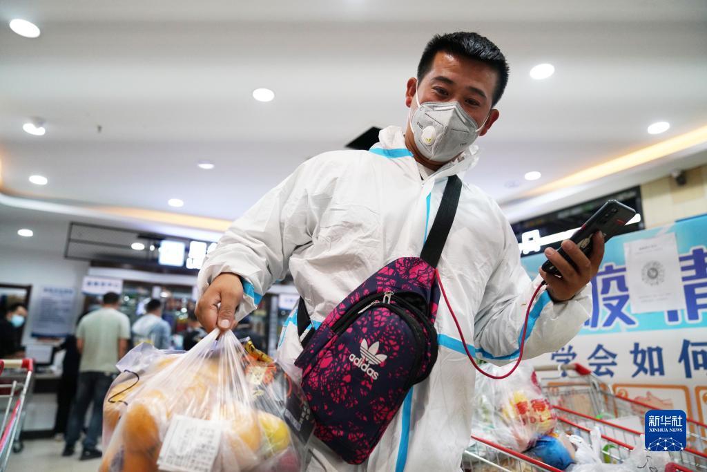 新华全媒 |穿防护服的配送小哥:多送一个单,多为抗"疫"尽一分力