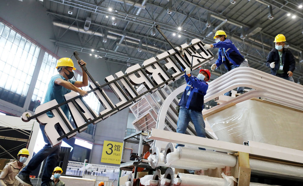 10月29日,施工人员在搬运用于第四届进博会展台搭建的材料.