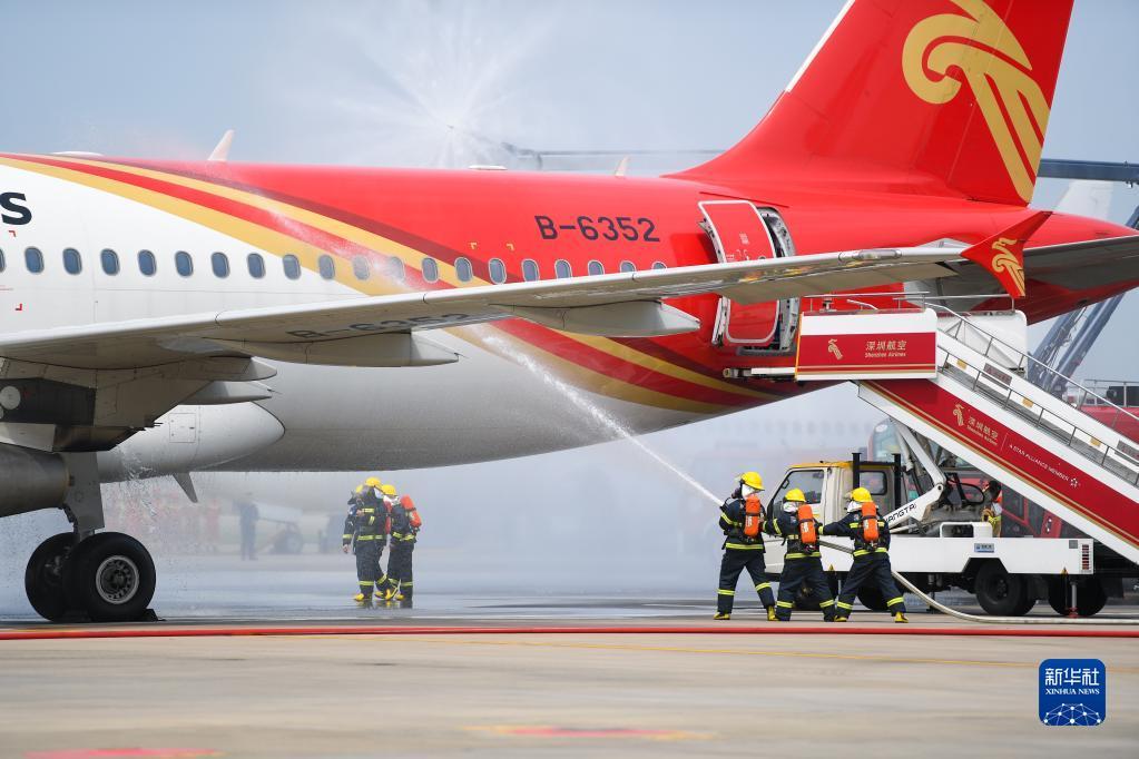 机场举行的演练中,航空器模拟因机械故障导致右发动机起火,消防员进行