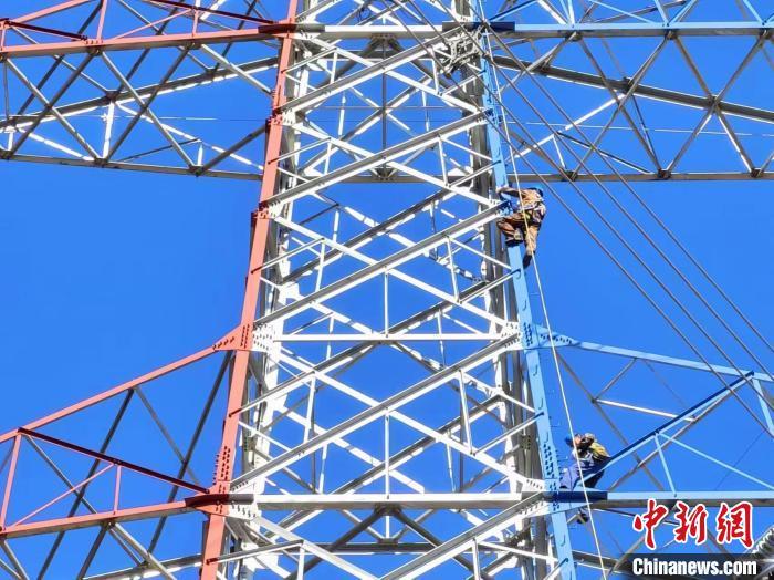电力人员攀爬上脚钉登上铁塔,准备走线检查.