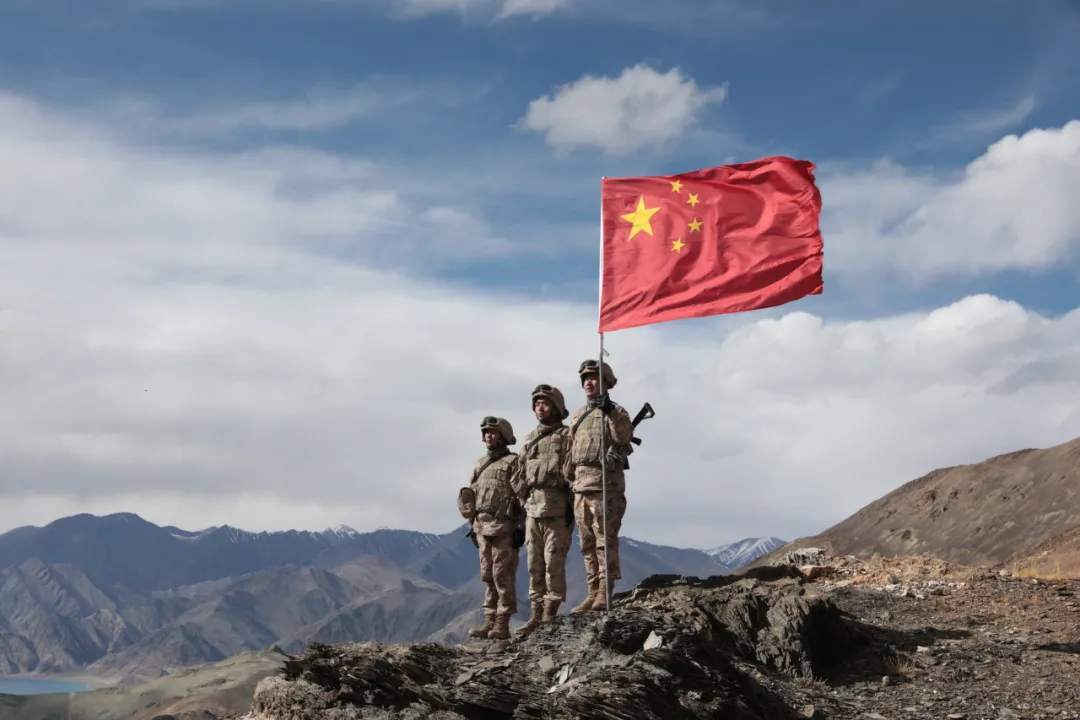 鲜艳的五星红旗迎风飘扬官兵们爬到山顶呼啸的寒风中哨所官兵再次踏上