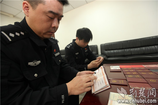 图为武汉铁路公安处民警正在清点查获的假铁路职工工作证等 (3)jpg